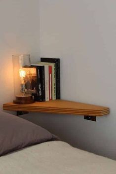 a bed room with a book shelf on the wall and a lamp next to it