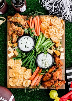 a football platter with chicken wings, carrots, celery and chips