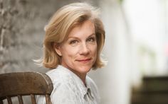 a woman sitting in a chair smiling at the camera