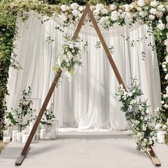 a wedding arch decorated with white flowers and greenery