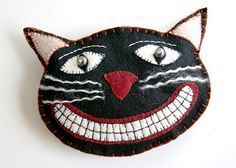 a close up of a black cat face on a white surface with eyes and teeth