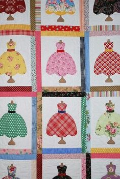 a quilted wall hanging with many different dresses on it