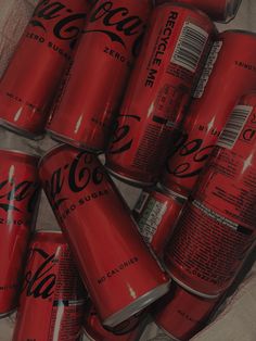 a bunch of coca cola cans sitting in a box