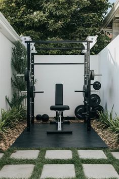 a home gym in the back yard with grass and plants on either side, there is an exercise station for two people