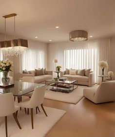 a living room filled with furniture and a chandelier above a glass top table