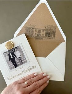 a hand holding an envelope with a wedding photo on it and a wax seal attached to the envelope