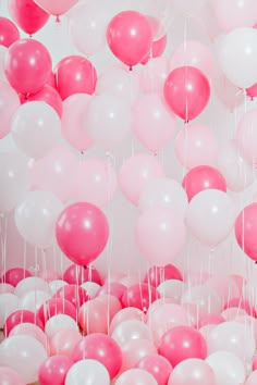 pink and white balloons floating in the air