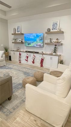 a living room filled with furniture and a flat screen tv mounted to the side of a wall