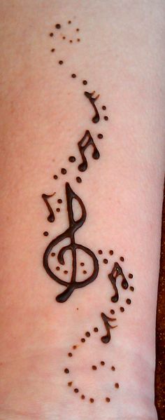 a woman's foot with music notes and musical notes drawn on the side of her leg