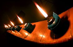 a row of lit candles sitting on top of a wooden table