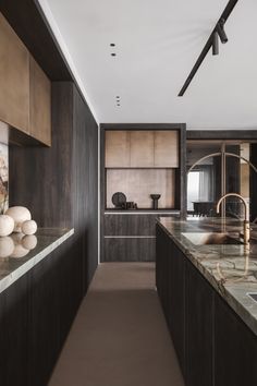 an elegant kitchen with marble counter tops and wooden cabinetry, along with modern appliances