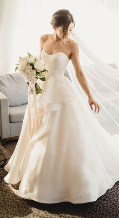 a woman in a wedding dress holding a bouquet