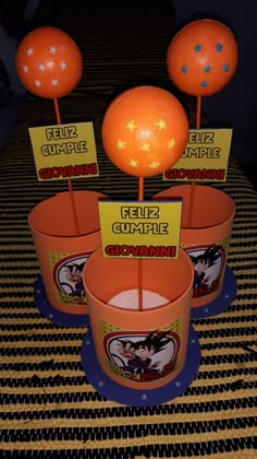 some oranges are sitting in buckets on a table with place cards and signs