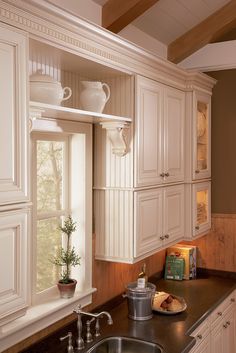 a kitchen with white cabinets and black counter tops, along with a sink in the center