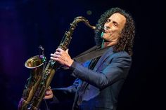 a man with long hair playing a saxophone