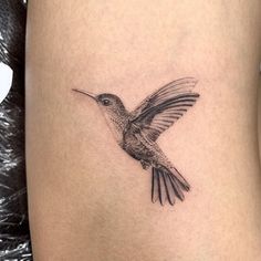 a small hummingbird tattoo on the thigh