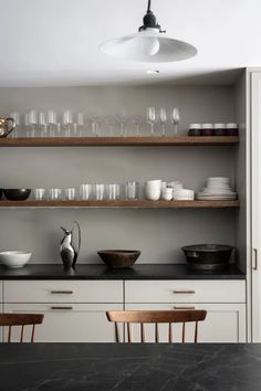 the shelves in this kitchen are filled with dishes and glasses