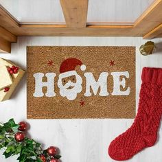 a door mat with the word home on it next to christmas decorations and stockings,