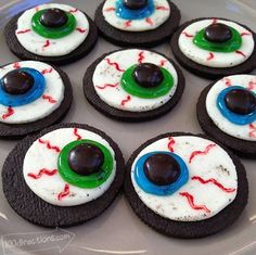 decorated cookies are arranged in the shape of evil eyeballs on a plate with green and blue icing