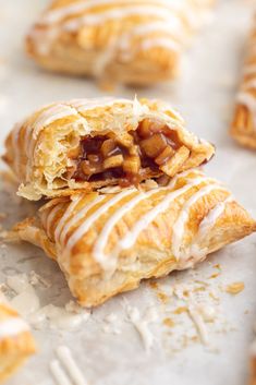 some food that is laying out on a piece of parchment paper with icing and nuts in it