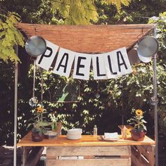 a wooden table topped with potted plants under a banner