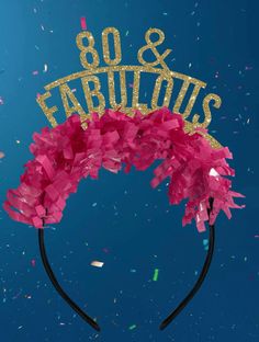 a pink headband with the words 80 and fabulous on it, surrounded by confetti