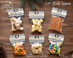 six bags of treats are sitting on a table next to pine cones and christmas decorations