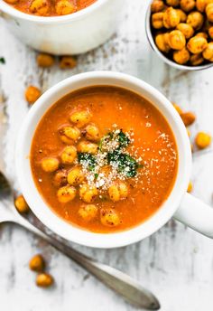 two bowls of soup with chickpeas and parmesan cheese on the side