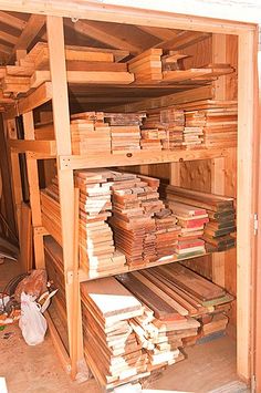 stacks of wood are stacked on top of each other in a storage room with no doors