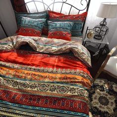 a bed covered in colorful blankets and pillows