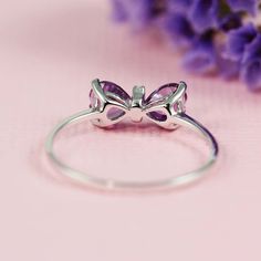 "The perfect dainty ring to add to your everyday outfit, as well as a great gift for any occasion. This bow ring can either be worn on its own, or you can even stack it with your other favorite pieces. The ring features both cubic zirconia and amethyst stone. Available in multiple sizes listed down below. The ring is made with sterling silver which means it is hypoallergenic. The material makes it perfect for everyday wear because sterling silver is durable and can take rough and tough wear. Wha Dainty Cubic Zirconia Heart Ring For Gift, Dainty Heart Ring With Cubic Zirconia As Gift, Dainty Heart Ring With Cubic Zirconia For Gift, Dainty Heart-shaped Crystal Ring As Gift, Dainty Cubic Zirconia Rings For Gift, Dainty Cubic Zirconia Rings As Gifts, Dainty Amethyst Ring For Gift, Dainty Diamond Ring For Valentine's Day Gift, Dainty Sterling Silver Diamond Ring Gift