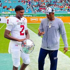 two football players on the field talking to each other