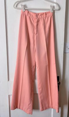 Unique and groovy 1970s bell bottom pants in a beautiful bright pink color. Excellent construction went into this garment and the pants are in great condition for their age. The pants feature a classic high waist, pleating, zipper and button closure, and appear to have never been worn. There is some slight pilling on the fabric near the back of the waistband, and some slight discoloration in a couple spots on the hems of fabric. Flaws are not very noticeable. Tag size says 7, but the pants are very small. Best fits a modern women's XXS/XS. Measurements (measured flat across, unstretched): Waist = 24" (doubled) Hips = 36" Inseam = 30" Rise = 12" Please read description carefully and view all photos. I describe and photograph all condition issues that I am aware of. I do my best to research Bell Bottom Trousers, High Waist Wide Leg Pants, Bell Bottom Pants, Bell Bottom, Bell Bottoms, Trousers Women, Vintage 70s, Bright Pink, Modern Woman