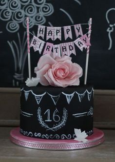 a black and pink birthday cake with a rose on top