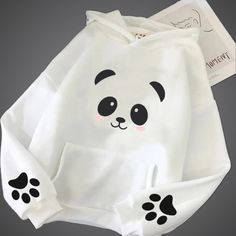 If you're looking for a combination of comfort and cuteness, this panda design white hoodie is just for you! Designed for those who want to feel both comfortable and playful in their daily life, this hoodie keeps you warm all day with its soft cotton fabric. The adorable panda face and cute paw prints will make you stand out wherever you go. This hoodie is your perfect companion for chilly days outside or cozy moments at home. Plus, with its unisex design, it's a piece everyone can enjoy wearing White Kawaii Hoodie For Streetwear, White Hooded Kawaii Top, White Kawaii Hoodie With Cartoon Print, White Kawaii Hoodie Top, White Kawaii Sweatshirt With Drawstring Hood, White Kawaii Sweatshirt For Streetwear, Kawaii White Hoodie Sweatshirt, White Kawaii Hoodie Sweatshirt, White Kawaii Hoodie With Drawstring