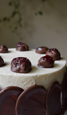 a cake with white frosting and chocolate candies on top