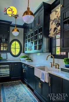 a kitchen with blue cabinets and white counter tops is pictured in this image, there are two pendant lights hanging from the ceiling