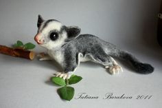 a small stuffed animal sitting on top of a table next to a leafy plant