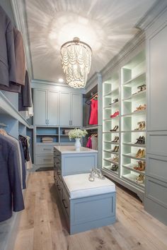 a walk in closet with blue cabinets and white shoes