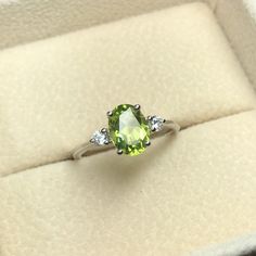 A simple silver setting with a 8x6mm Peridot and 2 2.75mm CZ accents. (prices subject to change depending on stone, metal, and size) ⇢Metal Available: ✦ Silver ✦ 14kt Gold Oval Peridot Birthstone Ring For May, Oval Lime Green Ring For Gift, Oval Peridot Birthstone Ring With Accent Stones, Lime Green Oval Rings With Accent Stones, Oval Peridot Birthstone Ring In Fine Jewelry, Peridot Oval Birthstone Promise Ring, Oval Peridot Birthstone Ring, Oval Peridot Rings With Accent Stones, Oval Peridot Birthstone Promise Ring