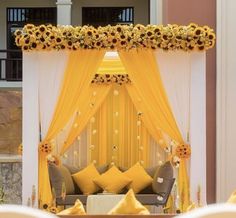 a decorated stage with sunflowers and yellow drapes