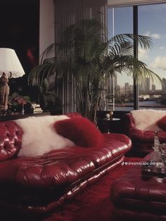 a living room filled with red leather furniture and a large window overlooking the cityscape