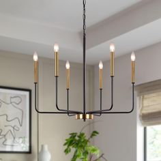 a chandelier with six lights hanging from it's center point in a dining room