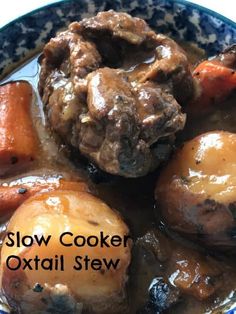 slow cooker oxtail stew in a blue and white bowl with carrots on the side