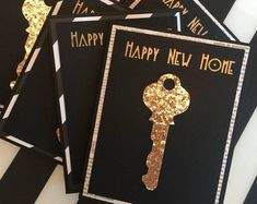 four black and gold new home cards with a key on them, one has the word happy new home written on it