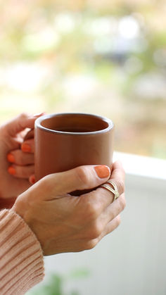 a woman holding a coffee cup in her hands