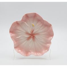 a pink flower shaped glass dish on a stand