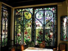 a dining room with stained glass windows and wooden chairs