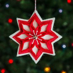 a red and white ornament hanging from a christmas tree