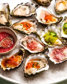 several oysters on a plate with dipping sauce